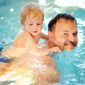 Papa mit Kind beim Schwimmenkurs