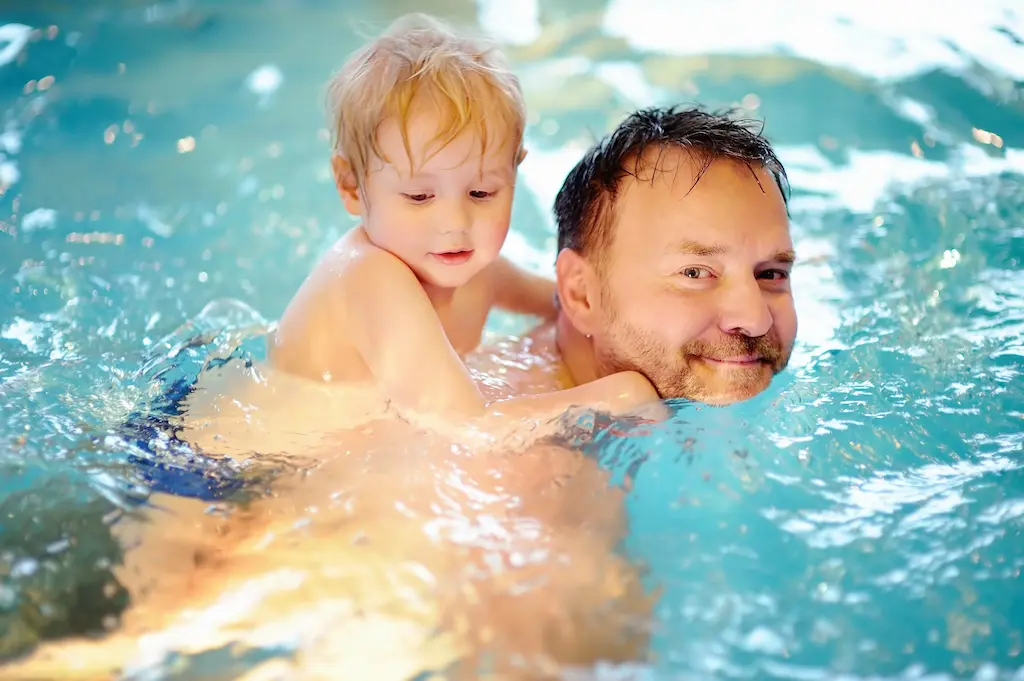 Papa mit Kind beim Schwimmenkurs