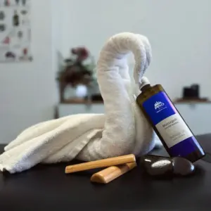 Handtuch als Schwan gefaltet mit Massage&ouml;l angelehnt symbolisch f&uuml;r Urlaubsatmosph&auml;re im R&ouml;merbad